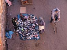 Trhovec prodávajíci v Marakéši boty