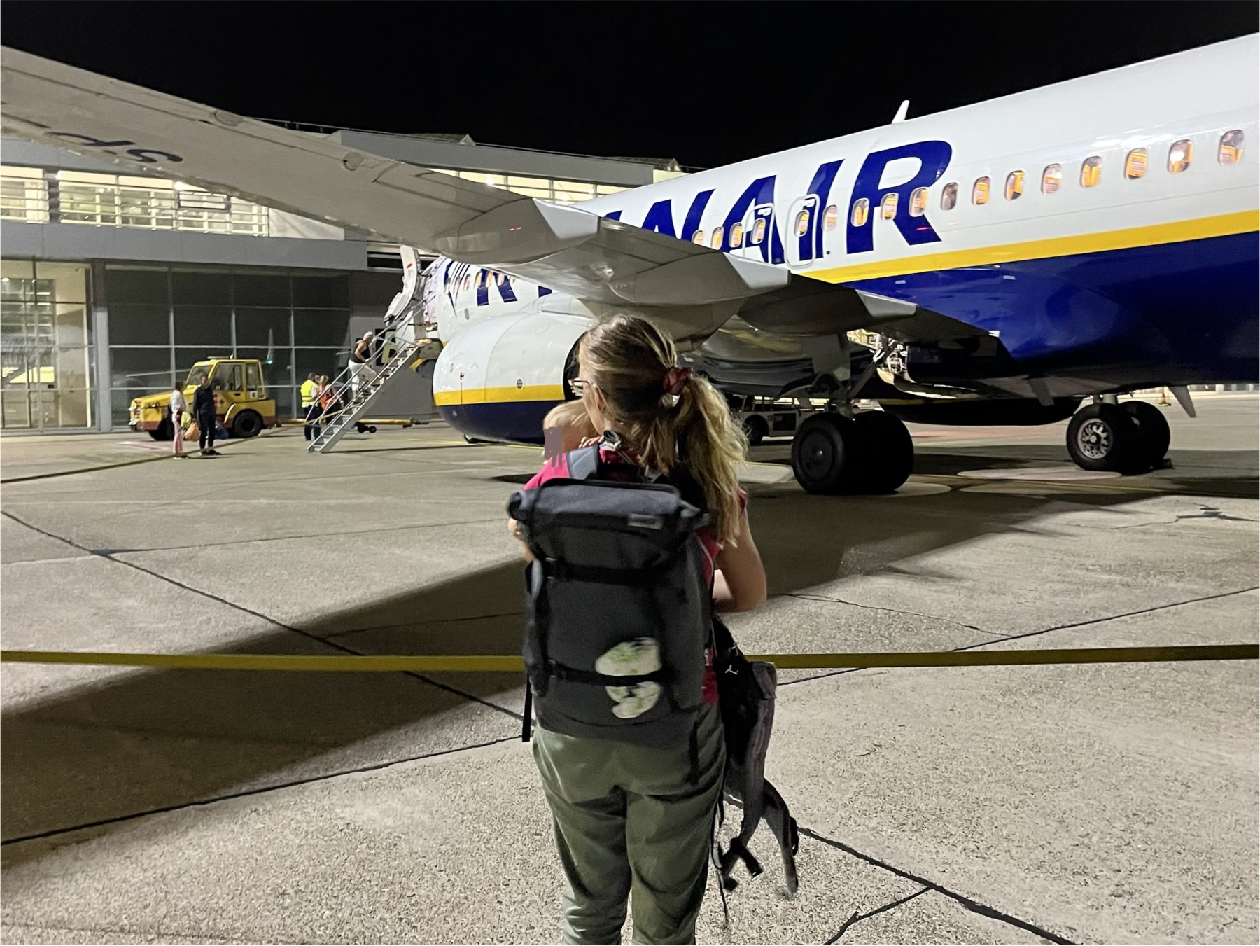 Tereza s dítětem a batohem při večerním nástupu do letadla Ryanair
