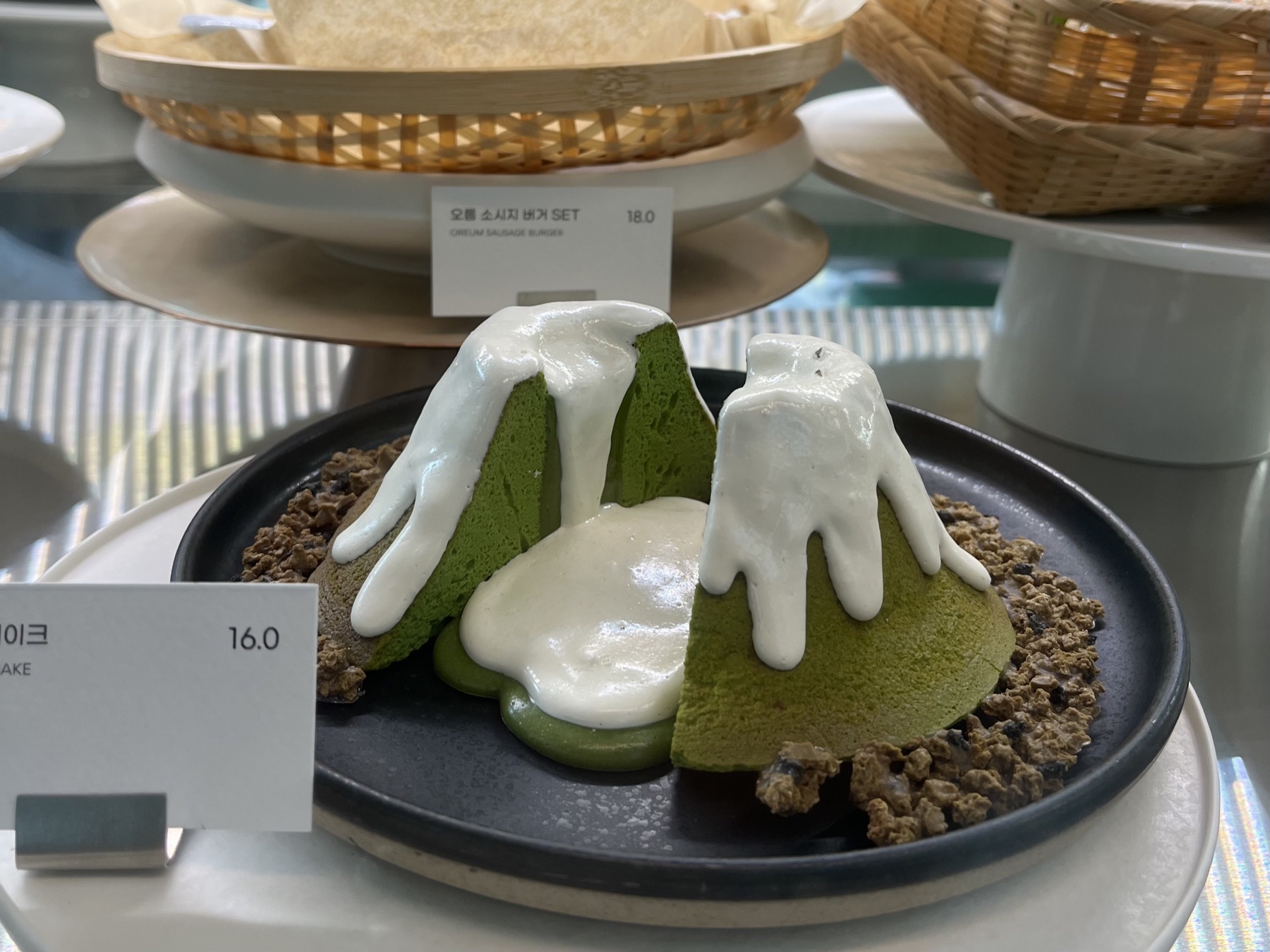 Zelený dezert ve tvaru sopečného kráteru s bílým krémem v Innisfree Jeju House