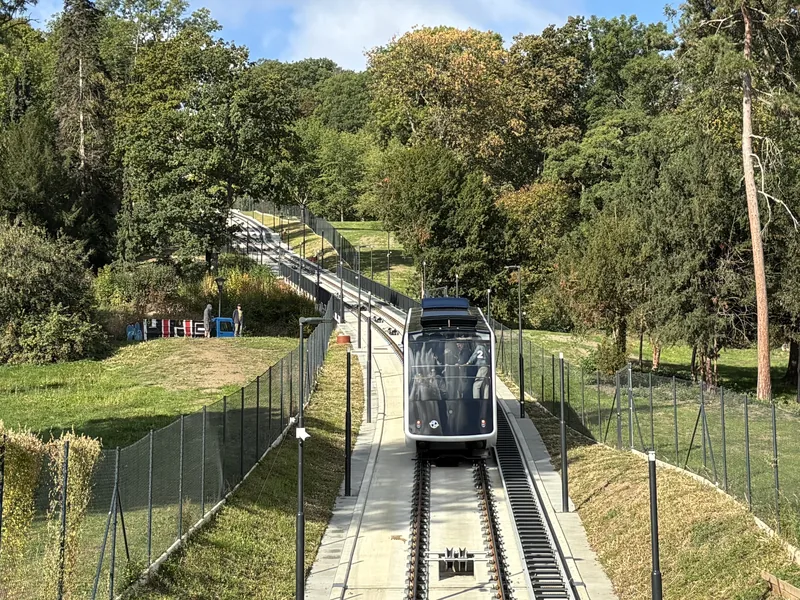 Nový černobílý vůz lanovky na Petřín na trati mezi stromy