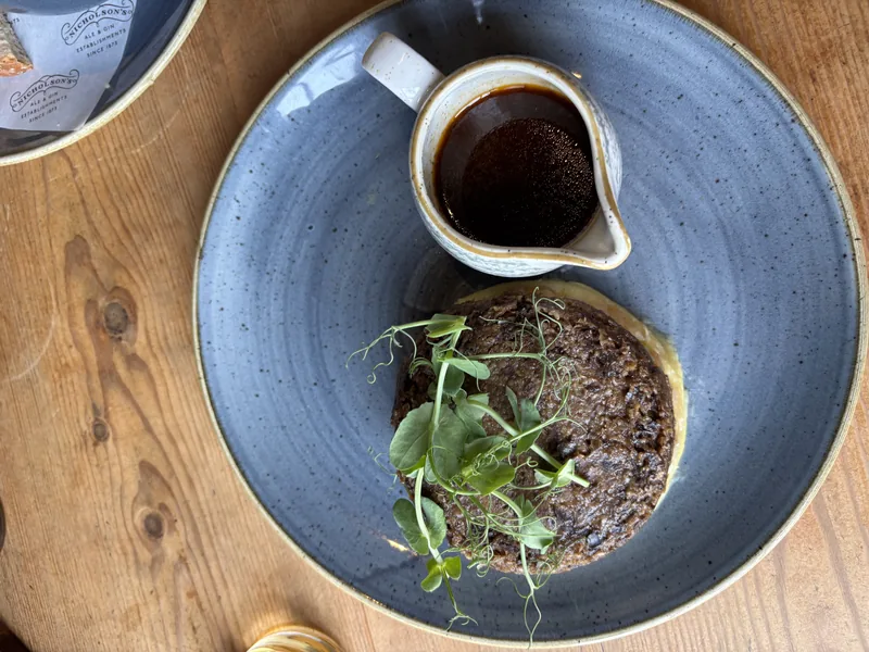 Porce haggis s přílohou a omáčkou na modrém talíři
