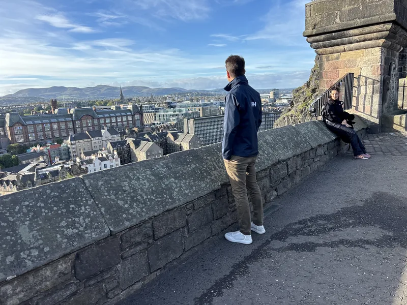 Martin u kamenné zídky s výhledem na Edinburgh před hradem