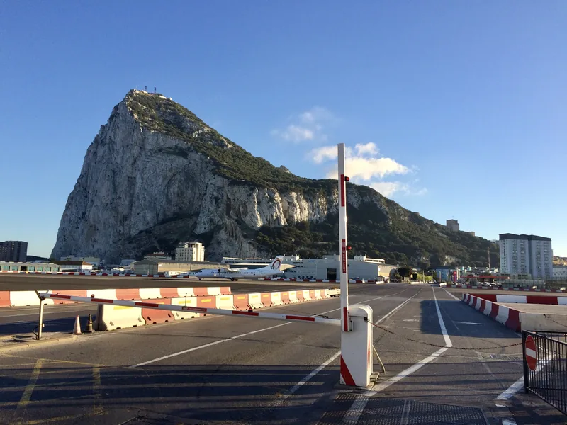 Letištní dráha se závorou a Gibraltarská skála v pozadí