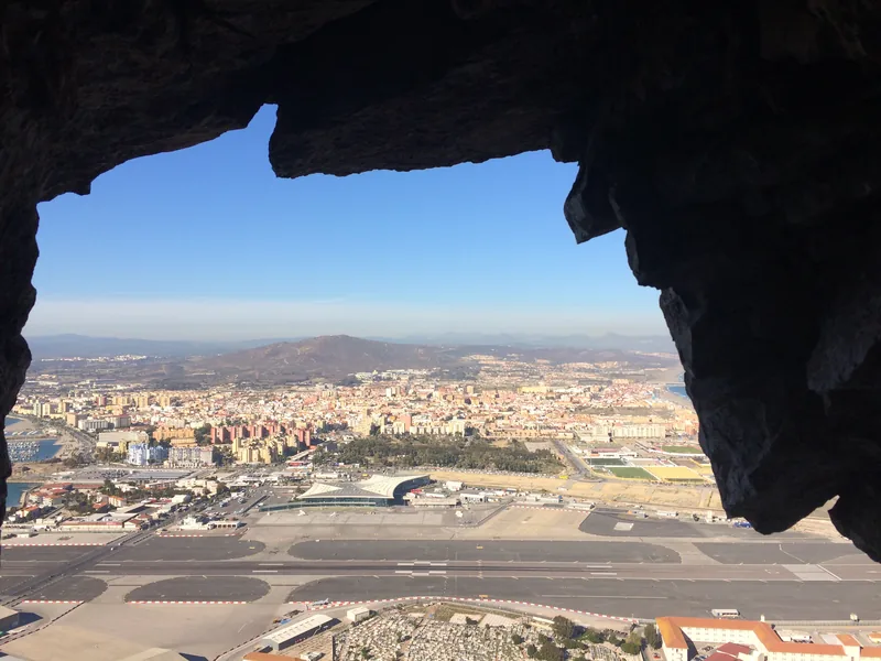 Pohled skalním otvorem na letiště Gibraltar a La Línea