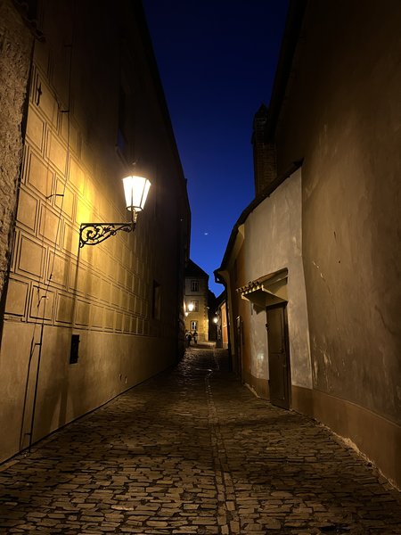 A narrow cobbled lane inside Prague Castle after dark